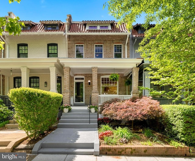 view of front facade with covered porch and brick siding