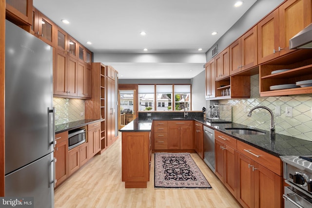kitchen with open shelves, light wood-style floors, range hood, a sink, and appliances with stainless steel finishes