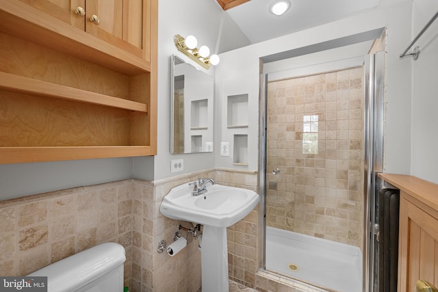 full bath featuring toilet, tile walls, and a stall shower