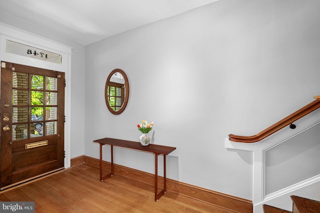 entrance foyer with stairway, baseboards, and wood finished floors