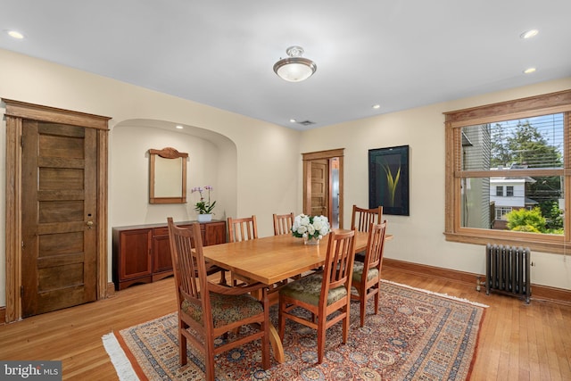 dining room with baseboards, light wood-style flooring, radiator, and recessed lighting