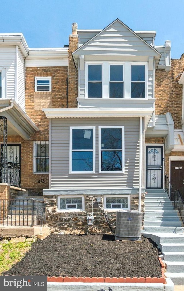 view of front of house featuring a chimney and central AC unit