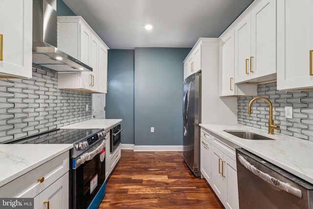kitchen featuring stainless steel appliances, backsplash, wall chimney range hood, and a sink