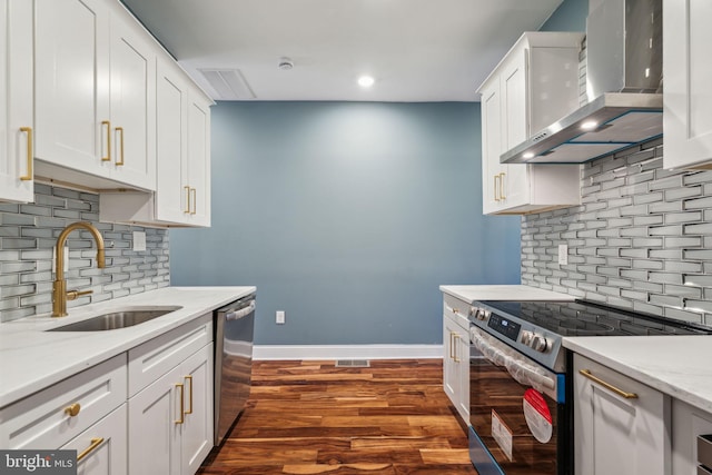 kitchen with appliances with stainless steel finishes, a sink, backsplash, and wall chimney exhaust hood
