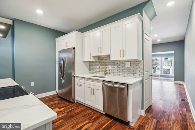 kitchen featuring dark wood finished floors, appliances with stainless steel finishes, decorative backsplash, and a sink