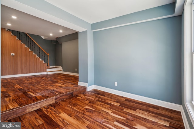 interior space featuring baseboards, stairway, wood finished floors, and recessed lighting