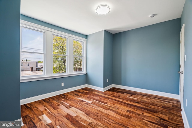 empty room featuring baseboards and wood finished floors
