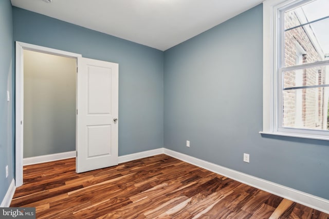 unfurnished room featuring wood finished floors and baseboards