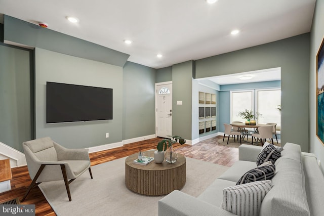 living room with wood finished floors, recessed lighting, and baseboards