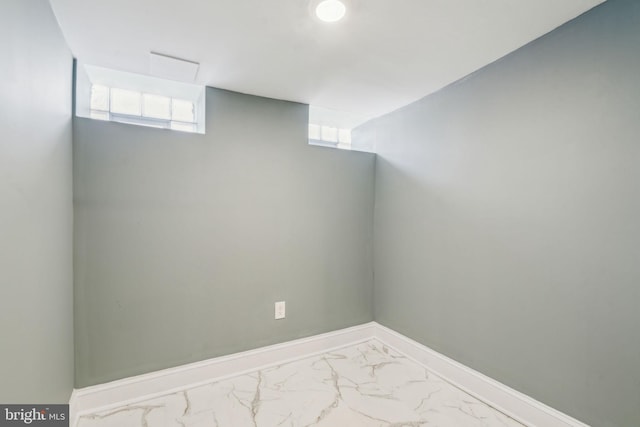 interior space featuring baseboards, plenty of natural light, and marble finish floor