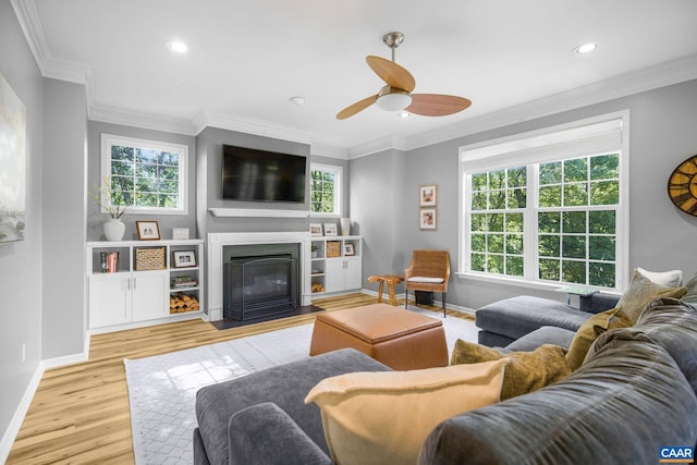 living area featuring a fireplace with flush hearth, baseboards, plenty of natural light, and a ceiling fan