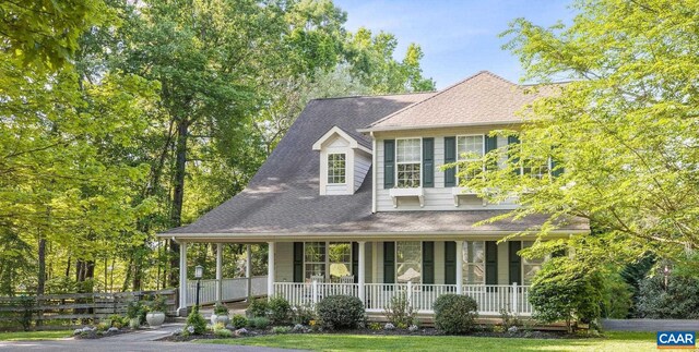 view of front of home with fence and a porch