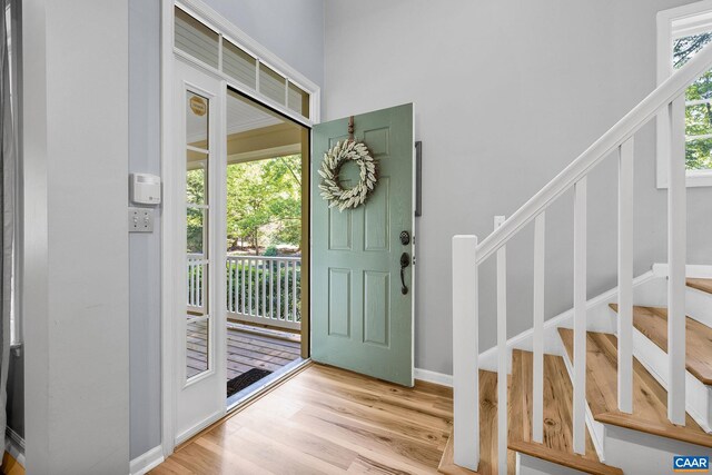 foyer with light wood finished floors and stairway