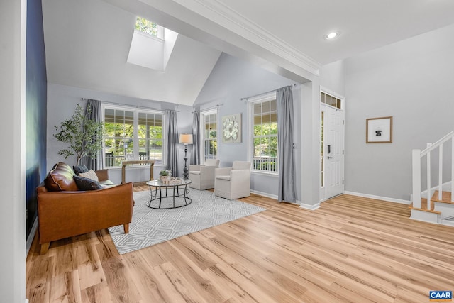 living room featuring a skylight, stairs, wood finished floors, and a wealth of natural light