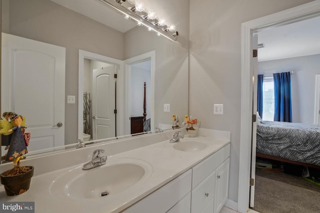 full bath with connected bathroom, double vanity, and toilet
