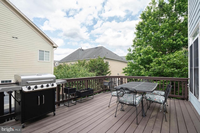 wooden terrace featuring outdoor dining area and grilling area
