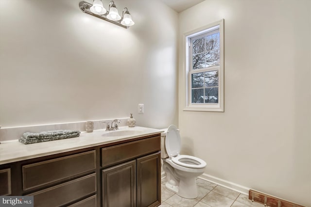bathroom featuring tile patterned flooring, baseboards, toilet, and vanity