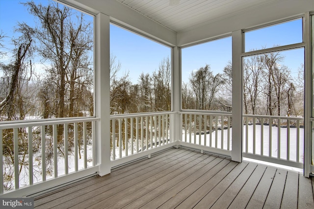 unfurnished sunroom featuring plenty of natural light, wood finished floors, and a deck