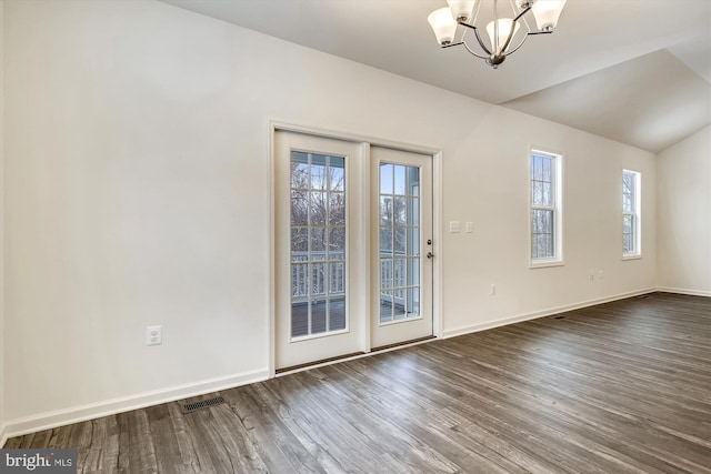 unfurnished dining area featuring baseboards, visible vents, dark wood-style floors, and a notable chandelier