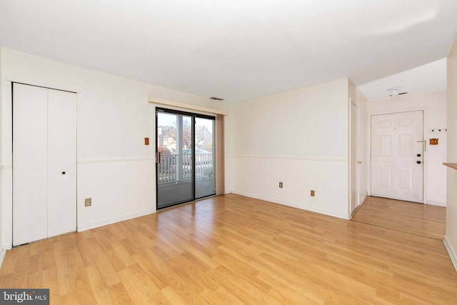 interior space with light wood finished floors, baseboards, and visible vents