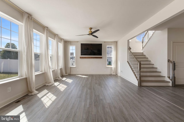 unfurnished living room featuring ceiling fan, a healthy amount of sunlight, and wood finished floors