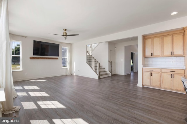 unfurnished living room featuring ceiling fan, stairs, baseboards, dark wood-style floors, and recessed lighting