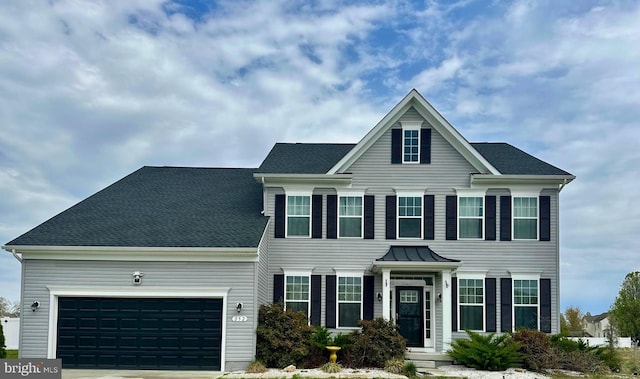 colonial inspired home featuring a garage and driveway
