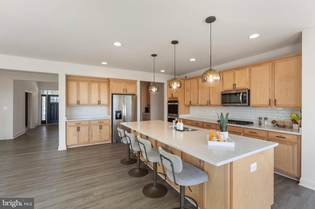 kitchen featuring light countertops, stainless steel appliances, a sink, and tasteful backsplash