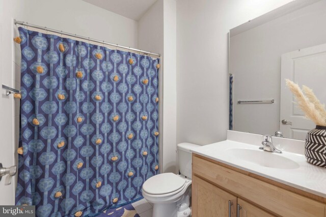 bathroom featuring toilet, a shower with shower curtain, and vanity