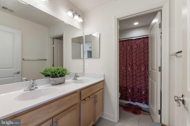 bathroom with double vanity, tile patterned floors, visible vents, and a sink