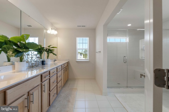 full bath with visible vents, a sink, tile patterned flooring, and a shower stall