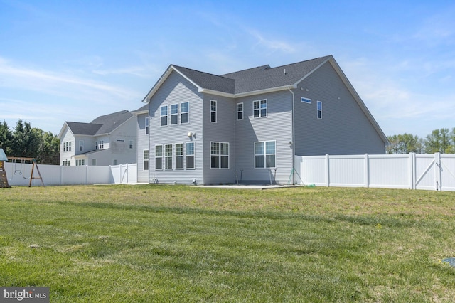 rear view of house featuring a lawn, a fenced backyard, and a patio area