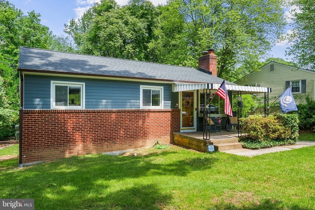 1826 Hylton Ave, Woodbridge, VA 22191 - back of property with a chimney, a lawn, brick siding, and a shingled roof