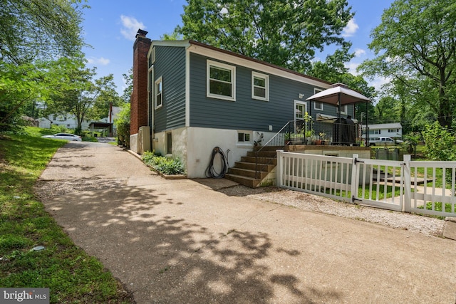 1826 Hylton Ave, Woodbridge, VA 22191 - view of front of property with a chimney, stairway, fence, and asphalt driveway