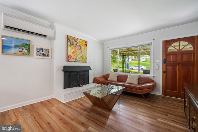 1826 Hylton Ave, Woodbridge, VA 22191 - living room with a wall unit AC, wood finished floors, ornamental molding, a brick fireplace, and baseboards