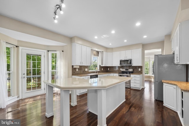 7883 Leroux Ln, Manassas, VA 20112 - kitchen with appliances with stainless steel finishes, a center island, decorative backsplash, white cabinetry, and recessed lighting