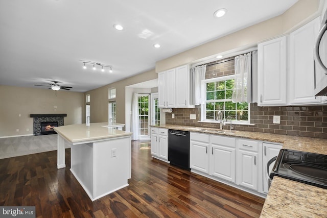 7883 Leroux Ln, Manassas, VA 20112 - kitchen featuring black appliances, a sink, a ceiling fan, a warm lit fireplace, and dark wood-type flooring