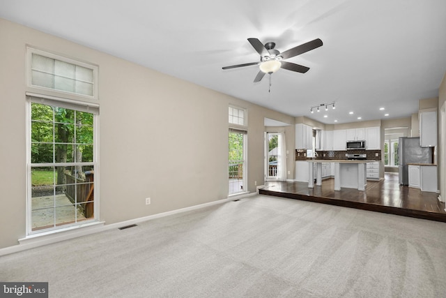 7883 Leroux Ln, Manassas, VA 20112 - unfurnished living room featuring ceiling fan, baseboards, and carpet floors
