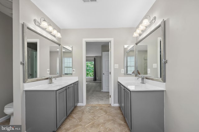 7883 Leroux Ln, Manassas, VA 20112 - full bath featuring two vanities, baseboards, and toilet