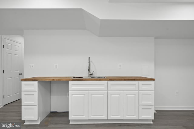 7883 Leroux Ln, Manassas, VA 20112 - kitchen featuring wooden counters, a sink, dark wood-style flooring, white cabinets, and baseboards