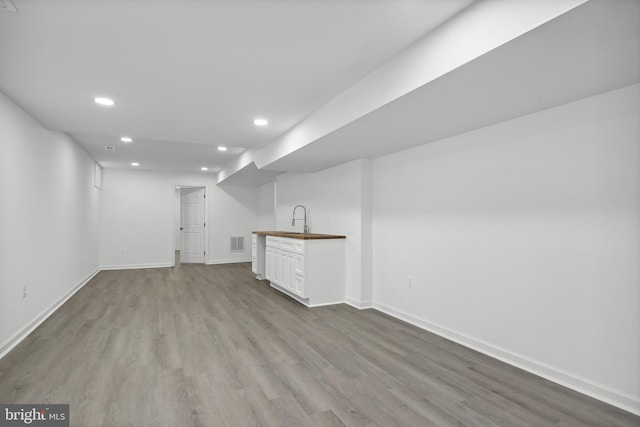 7883 Leroux Ln, Manassas, VA 20112 - finished basement with recessed lighting, wood finished floors, baseboards, and bar with sink