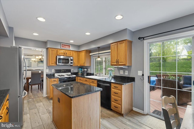 3565 Hummock Pl, Woodbridge, VA 22192 - kitchen featuring appliances with stainless steel finishes, a center island, light wood-style floors, dark stone countertops, and a sink