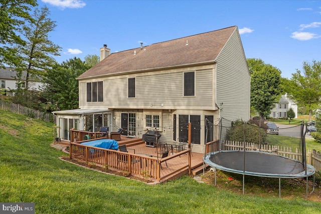 3565 Hummock Pl, Woodbridge, VA 22192 - rear view of property featuring a trampoline, a chimney, a wooden deck, a sunroom, and roof with shingles