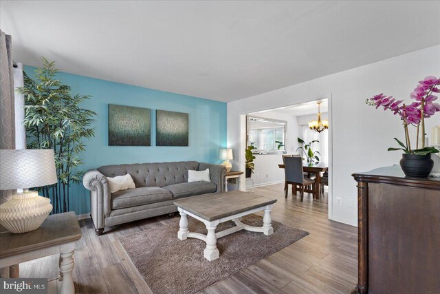 3565 Hummock Pl, Woodbridge, VA 22192 - living room with a chandelier, wood finished floors, and baseboards