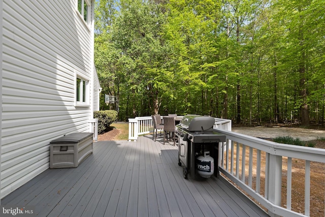 wooden terrace with outdoor dining space and grilling area