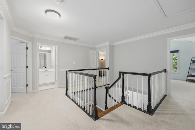 corridor with crown molding, carpet, and an upstairs landing