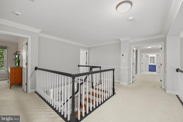 hall featuring crown molding, an upstairs landing, light carpet, and attic access