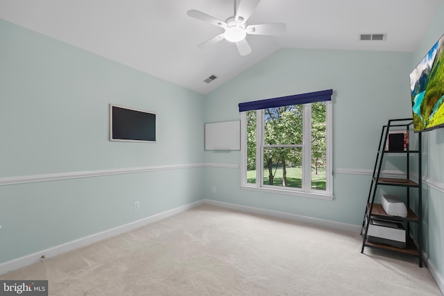 carpeted spare room featuring ceiling fan, visible vents, baseboards, and lofted ceiling
