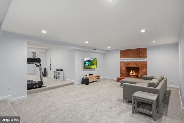 living room featuring baseboards, light carpet, a brick fireplace, and recessed lighting