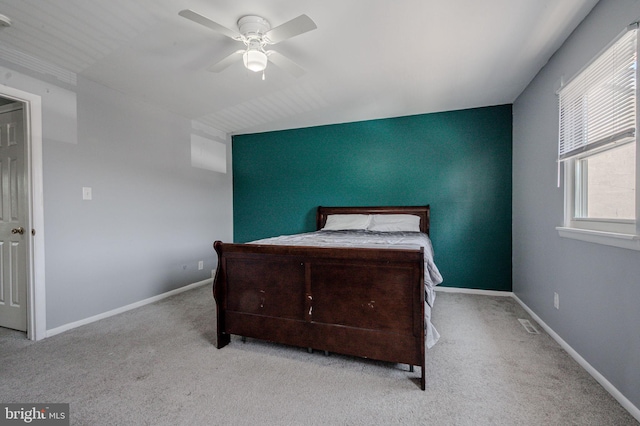 carpeted bedroom featuring baseboards, multiple windows, and a ceiling fan